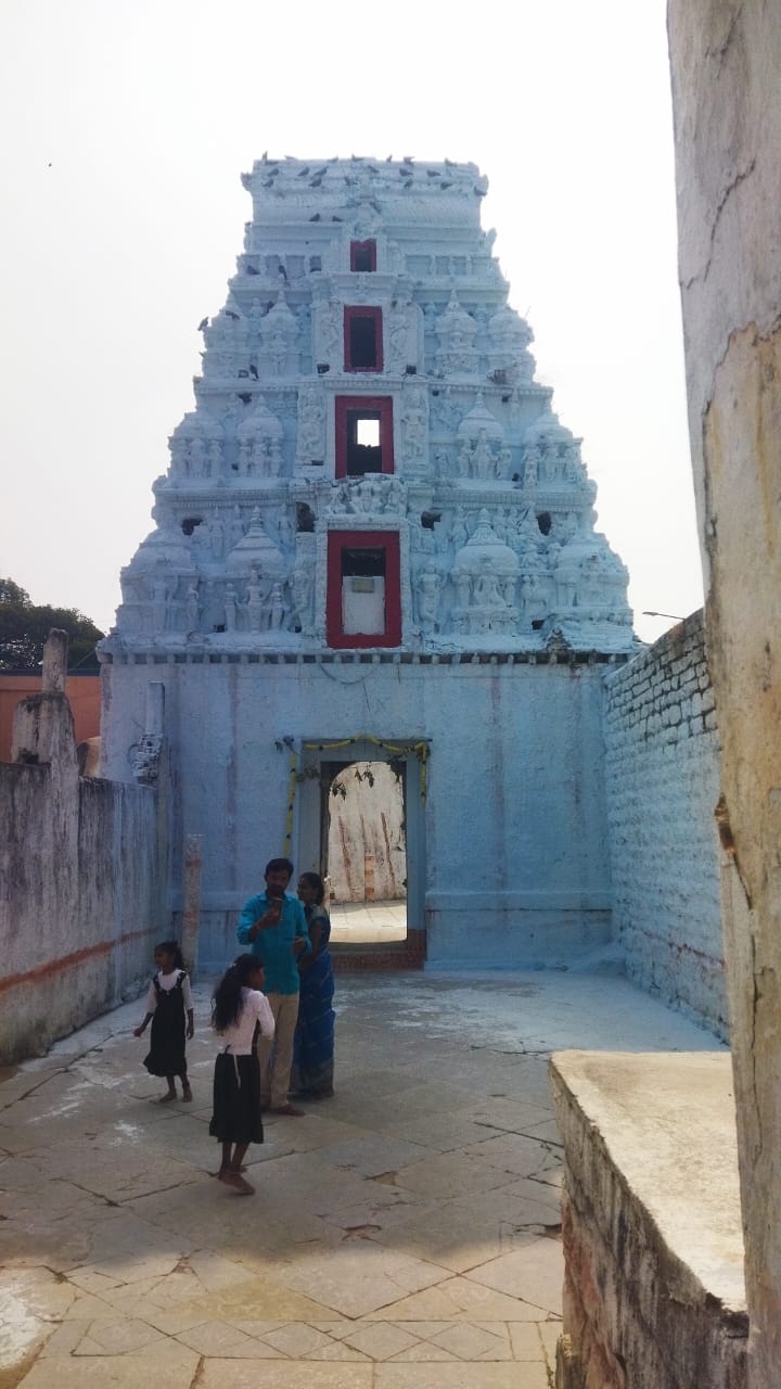 Devotees in the stone-paved courtyard before the inner gopuram